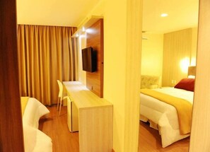 A hotel room with a bed, a desk, and a television. - Imigrantes Hotel (Santa Rosa)