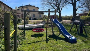 A backyard with a wooden swing set, a blue slide, and a red hanging swing. - Apartment 1 with 2 bedrooms (4 adults + infant) on the ground floor - Villa Seeheim Ferienobjekt direkt (Boiensdorf)