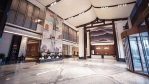 A spacious lobby with a marble floor, large windows, and a reception area with a modern design.