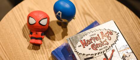 Ein Holztisch mit einem Marvel Age Comics Buch und zwei Actionfiguren.