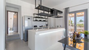 Una cucina moderna con isola centrale, elettrodomestici in acciaio inossidabile e zona pranzo con tavolo e sedie.