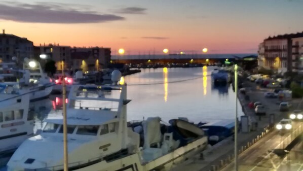 A marina with boats docked, a bridge in the background, and buildings along the waterfront. - vue Formidable au Coeur de Sète (Sète)