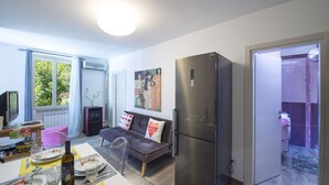 A compact living space with a dining area, sofa, and a large refrigerator. - Sapphire house amalfi coast sea view (Minori)