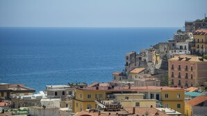A coastal town with buildings along the sea, featuring a mix of architectural styles and a clear view of the ocean. - Sapphire house amalfi coast sea view (Minori)