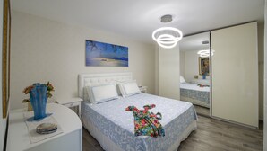 A bedroom with a bed, white nightstands, a vase with flowers, a painting on the wall, and a mirror. - Sapphire house amalfi coast sea view (Minori)