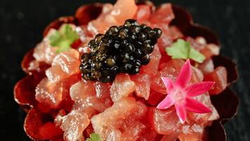 A dessert with caviar and a pink flower on top.