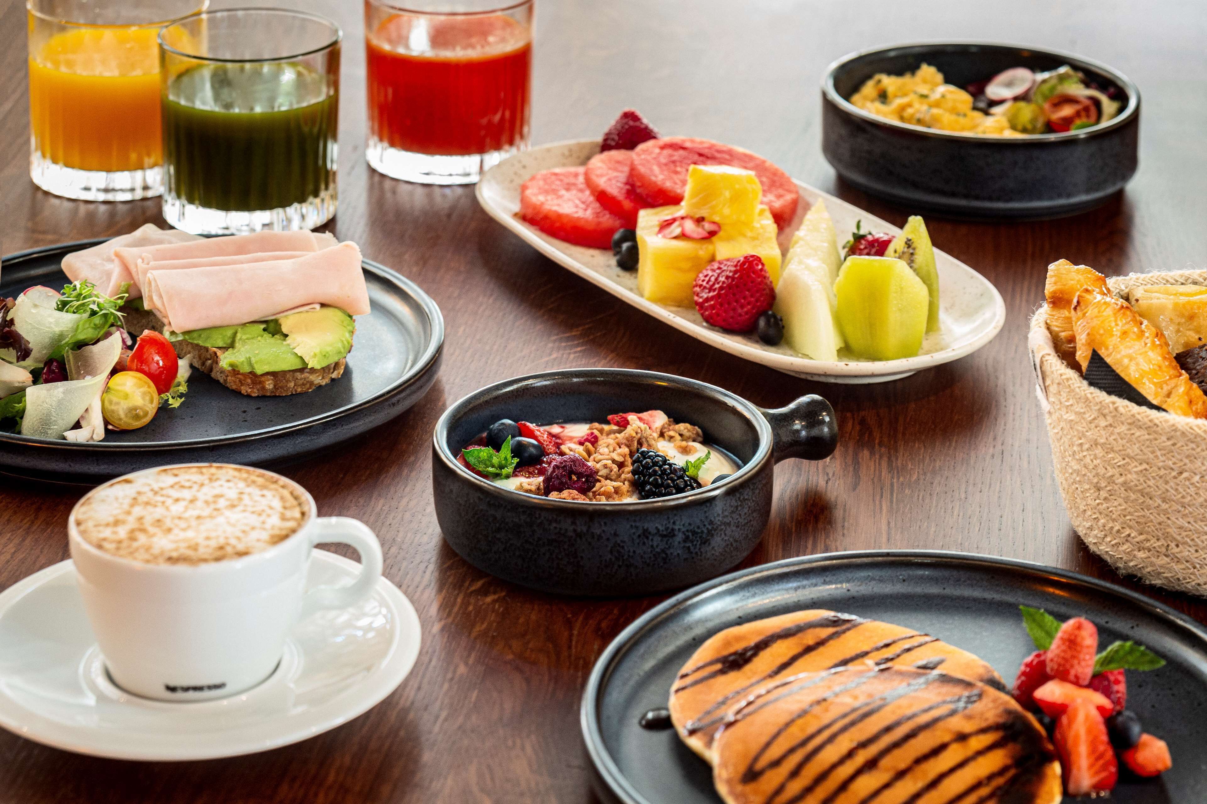 Un desayuno con diferentes platillos, bebidas y una taza de café.