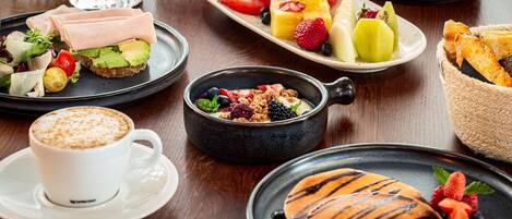 Una colazione con diversi piatti, bevande e una tazza di caffè.