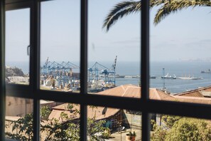 A coastal port with shipping containers, cranes, and a ship docked. - Casablu Hotel (Valparaiso)