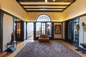 Une pièce spacieuse avec un grand tapis à motifs, un canapé et une grande fenêtre en arc de cercle.