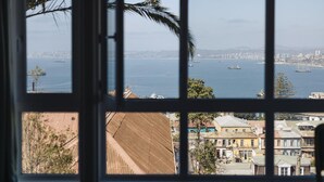 Vista a través de una ventana con un paisaje urbano y agua de fondo.