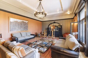 A living room with a sofa, armchairs, a coffee table, and a chandelier.