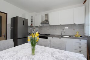 Appartement, 3 chambres, balcon | Cuisine privée | Réfrigérateur, micro-ondes, four, plaque de cuisson