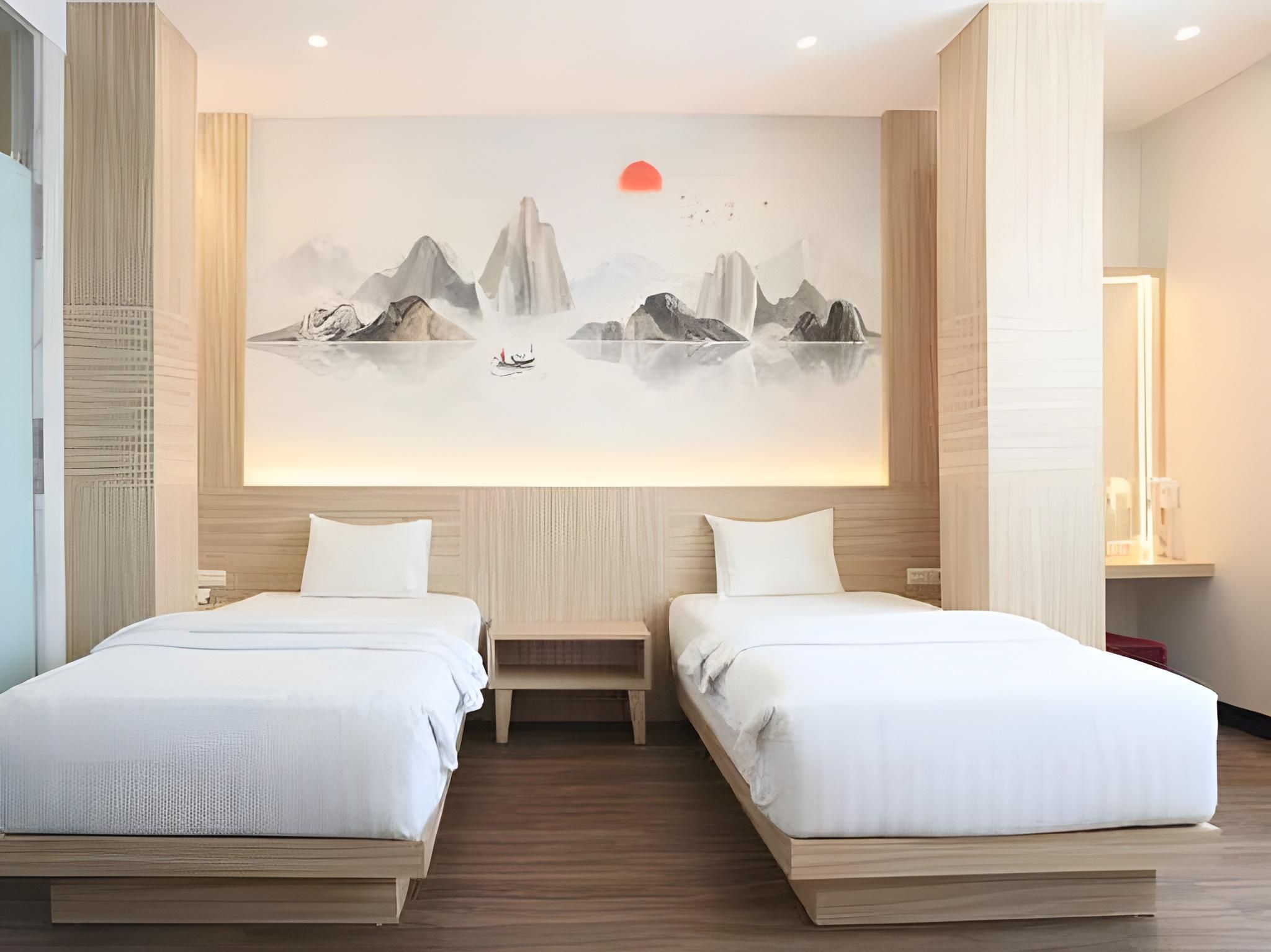 Une chambre d’hôtel avec deux lits, une grande fresque murale et une table de chevet.
