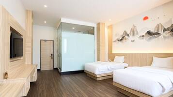 A hotel room with a bed, a TV, and a painting on the wall.