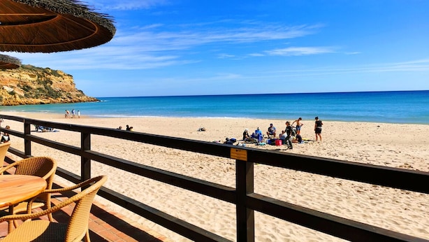 A beach with a wooden deck, wicker chairs, and a thatched umbrella. - Family-friendly villa has private pool, short walk to Burgau Beach (Burgau)
