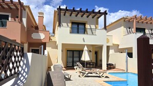 A two-story building with a pool, outdoor seating, and a pergola. - Family-friendly villa has private pool, short walk to Burgau Beach (Burgau)