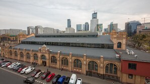 A train station with a large building featuring arched windows and a flat roof. - ShortStayPoland Plac Mirowski (Warsaw)