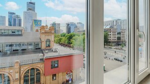 A cityscape with modern and historic buildings, a clear sky, and a view of a busy street. - ShortStayPoland Plac Mirowski (Warsaw)