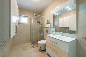 Villa | Badkamer | Een douche, een regendouche, gratis toiletartikelen, een haardroger