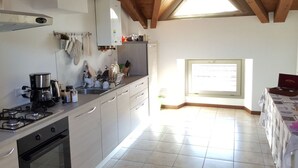 Une cuisine équipée d’une cuisinière à gaz, d’un four et d’une fenêtre donnant sur un beau paysage.
