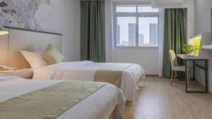 Habitación de hotel con dos camas, un escritorio con silla, un mapa en la pared y una ventana con cortinas.