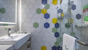 Un baño con lavamanos, espejo y ducha.