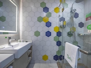 Un baño con lavamanos, espejo y ducha.