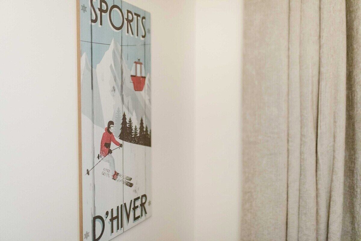 A poster with a skier on a mountain, the word 'SPORTS,' and 'D'HIVER' on a wall.