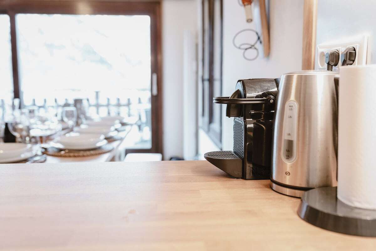 Une machine à café et une bouilloire sur une table en bois, dans un décor de restaurant.