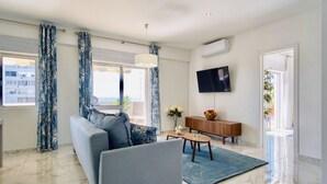 A modern living room with a sofa, coffee table, and a flat-screen TV. - Premium w terrace. 2 min 2 beach, 90 sqm, Algarve (Quarteira)