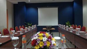 A conference room with a long table, chairs, water bottles, and a projector screen. - Arte Yogyakarta (Yogyakarta)
