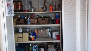 Ein ordentlich eingerichteter Vorratsschrank mit Regalen, gefüllt mit verschiedenen Lebensmitteln, Geschirr und Aufbewahrungsbehältern.
