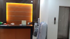 A reception area with a wooden reception desk, a bulletin board, and a wall-mounted clock.