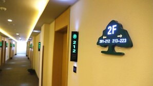 A hotel corridor with a sign indicating room number 212 and a tree-shaped sign with room numbers 201-212 and 213-223. - Greentree Inn Business Hotel (Shenyang Huaxiang Shengjing Hospital) (Shenyang)