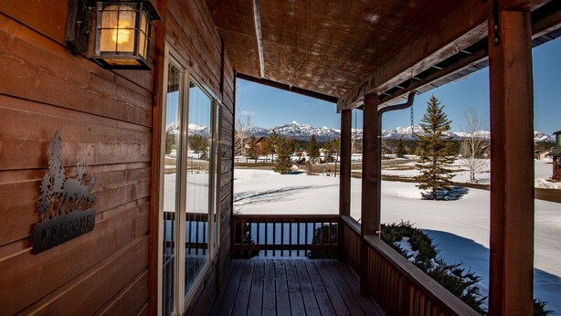 A wooden cabin with a porch, a welcome sign, and a view of snow-covered mountains. - AC! Beautiful, Cozy Home, Walk to Village Lake (Pagosa Springs)