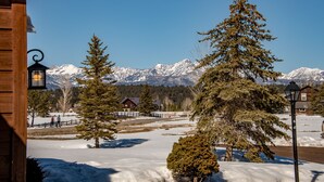 A snowy landscape with a wooden building, a wooden fence, and a mountain range in the background. - AC! Beautiful, Cozy Home, Walk to Village Lake (Pagosa Springs)
