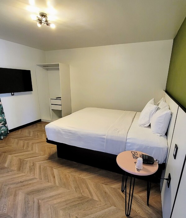 A neatly arranged bedroom with a bed, bedside table, and a wardrobe.
