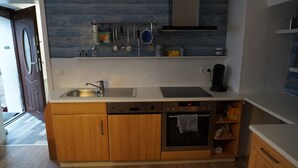 Une cuisine moderne équipée d’un lave-vaisselle, d’un four et d’un évier en acier inoxydable.