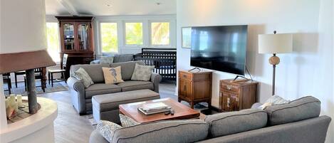Una sala moderna con un sofá modular, una mesa de centro, un televisor y una chimenea.