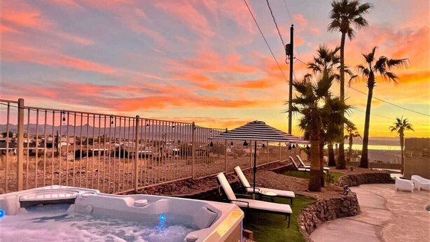 A hot tub with lounge chairs and a view of the sunset. - Trendy Getaway + Pool, Spa, Game Room, Views (Lake Havasu City)