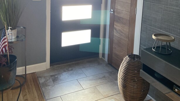 A modern interior with a wooden door, a wall-mounted shelf, a wicker basket, and a small table. - Modern House in Wyandotte (Wyandotte)