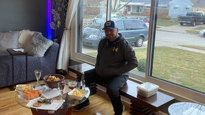 A living room with a large window, a glass coffee table with snacks, a sofa, and a decorative light. - Modern House in Wyandotte (Wyandotte)
