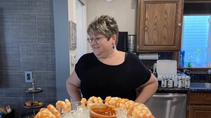 A kitchen with a countertop displaying shrimp skewers, a small bowl of sauce, and a tray of sliced meats. - Modern House in Wyandotte (Wyandotte)
