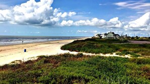 Ein Strandgrundstück mit einem großen Haus und einem Sandstrand.