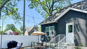 A backyard with a barbecue grill, outdoor seating, and a fire pit.