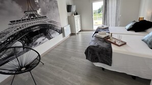 A bedroom with a large Eiffel Tower mural, a bed, a chair, and a dresser. - Rural House Altaret (Callosa d'en Sarrià)