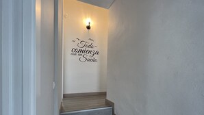 A staircase with a wall-mounted light fixture and a decorative sign. - Rural House Altaret (Callosa d'en Sarrià)