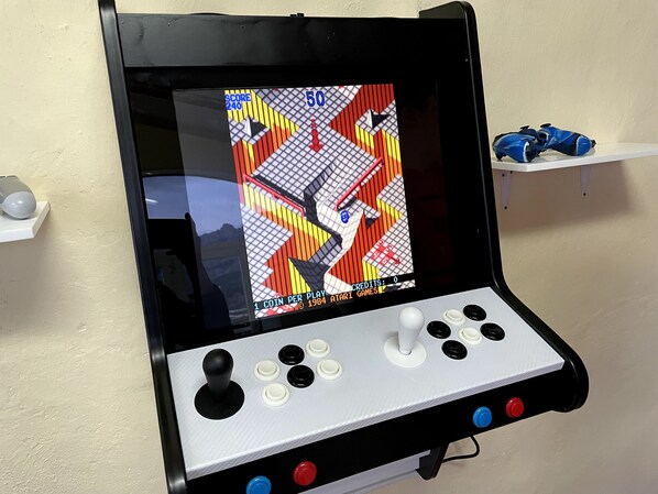 Eine Retro-Spielkonsole mit Anzeige für den Punktestand, Joysticks und Tasten.