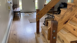 A wooden staircase with a handrail leading to a landing. A bench and a chair are placed on the landing. - Wellfleet Woodlands Escape - Privacy in the Pines! (Wellfleet)
